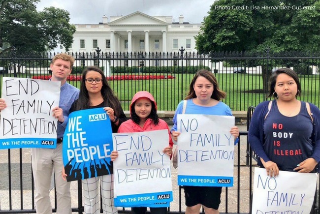 Five people holding up signs that read "End family detention" and "We the people"