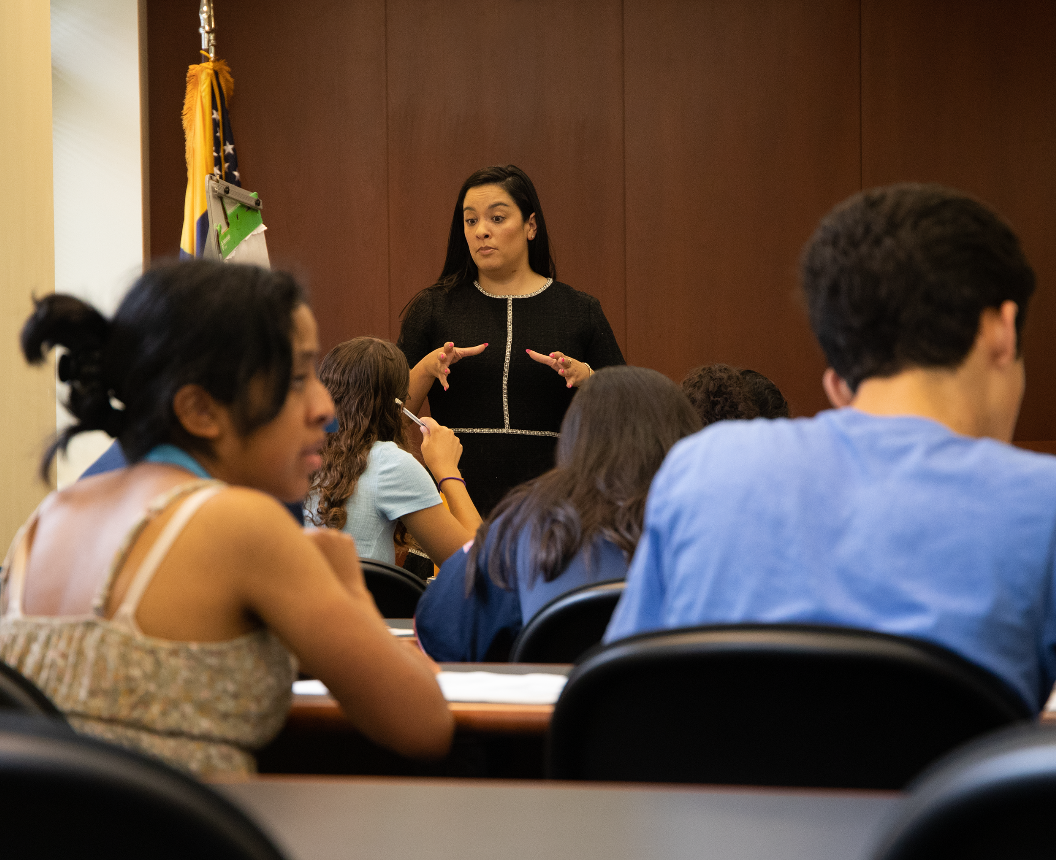professor speaking with students in a classroom