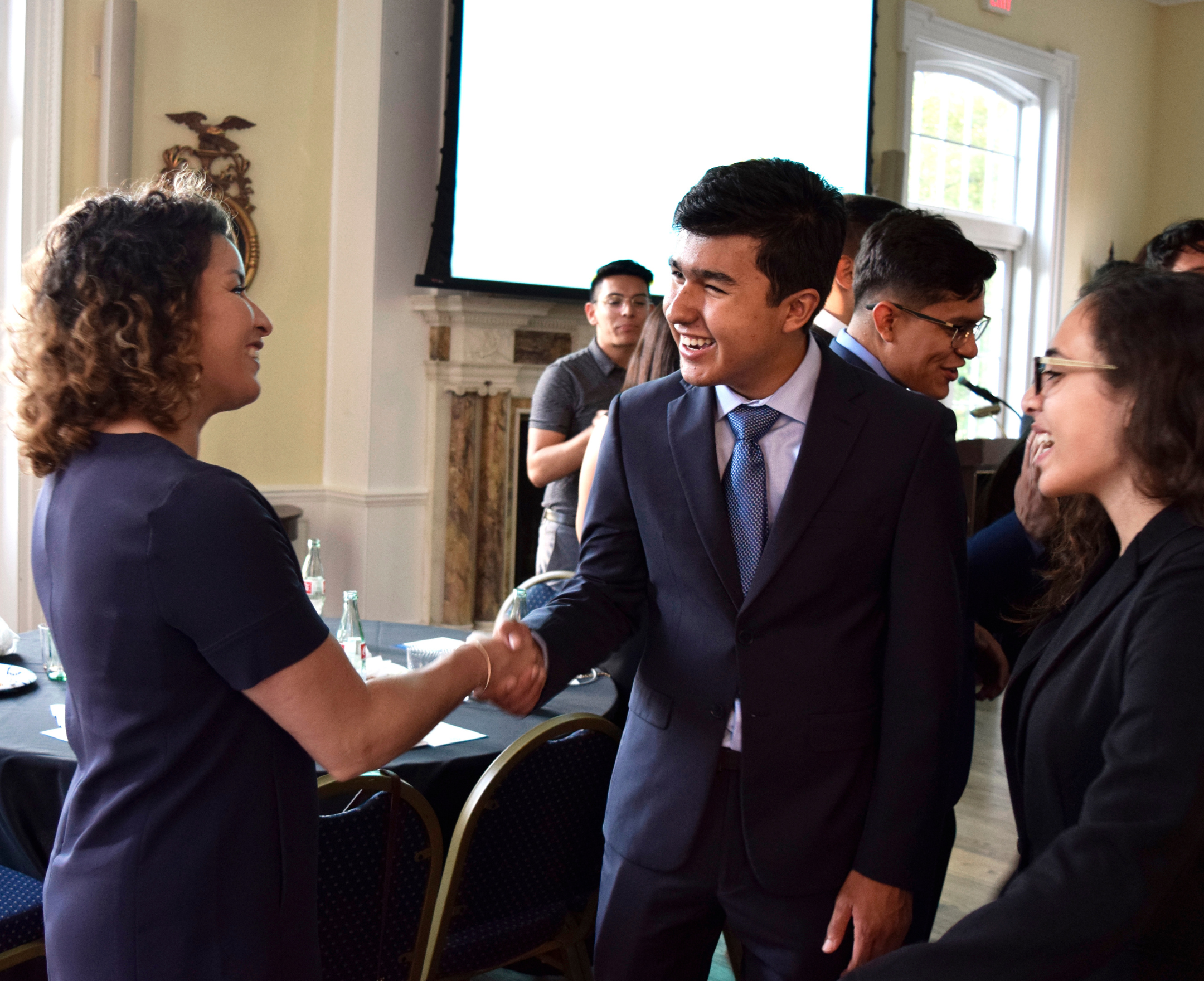 student shaking hands with another person