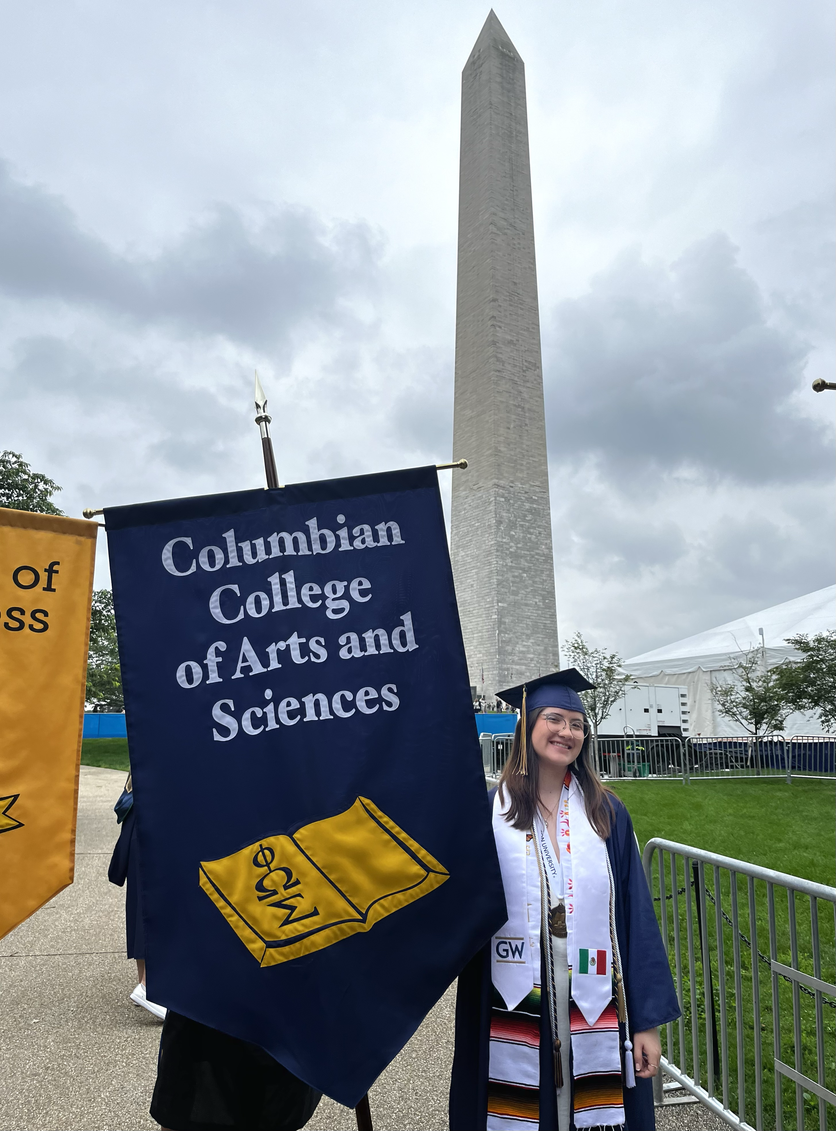 Student holding up a flag that reads, "Columbian College of Arts and Sciences"
