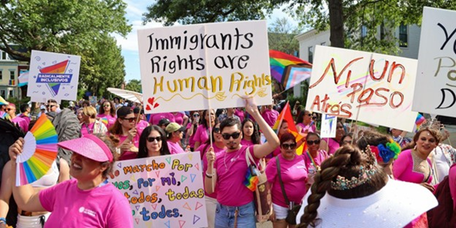 Multiple people at a protest holding up signs