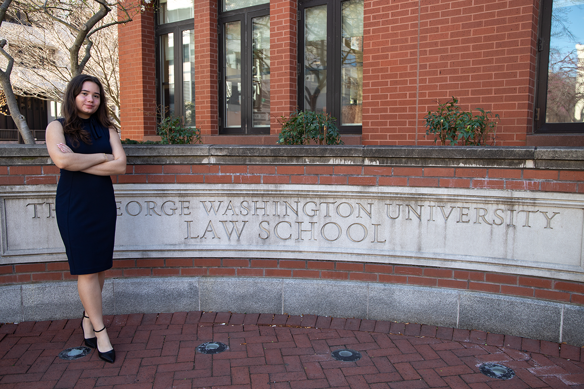 Student stands in front a law school building