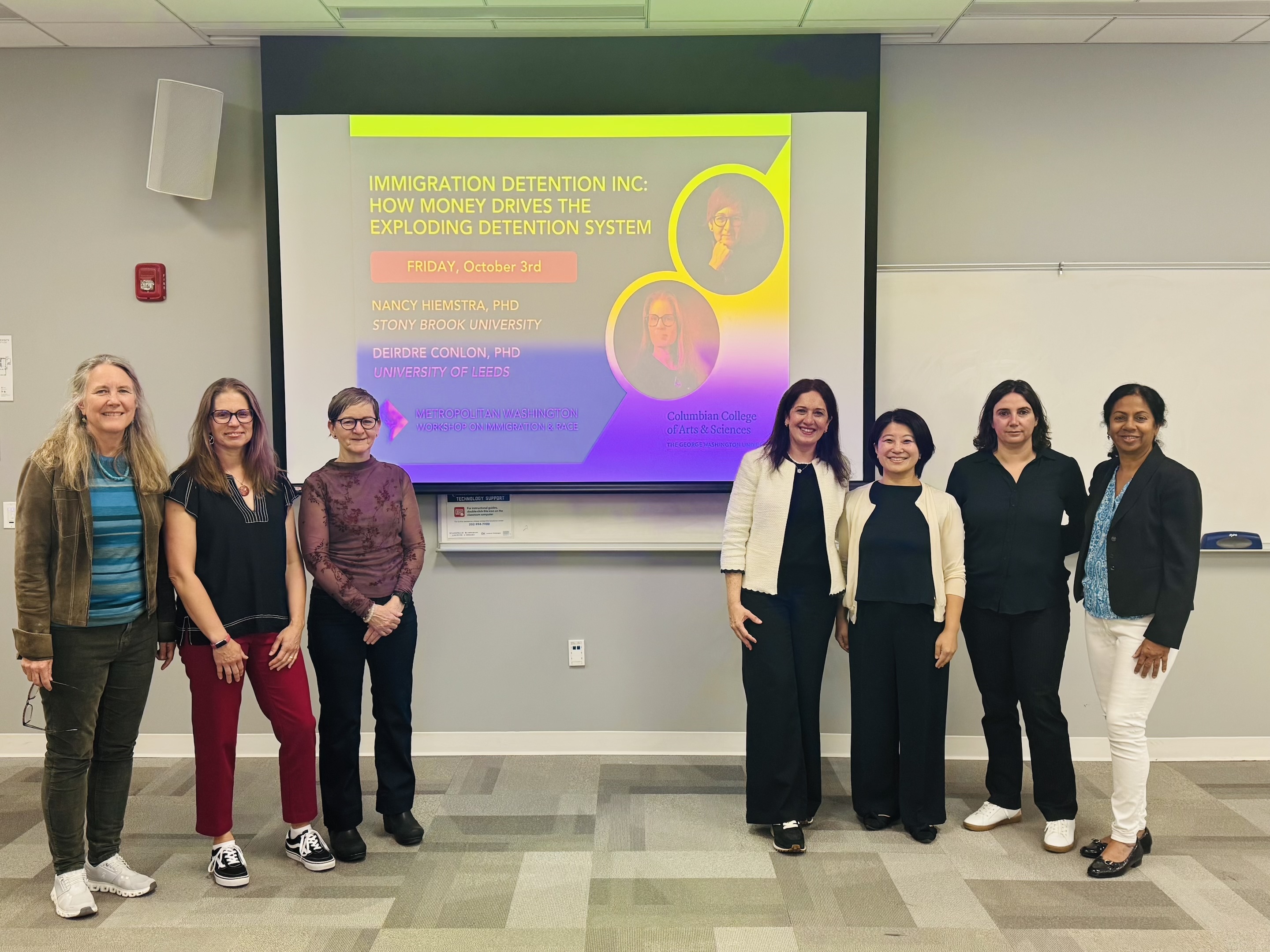 Presenters stand in front of their slides