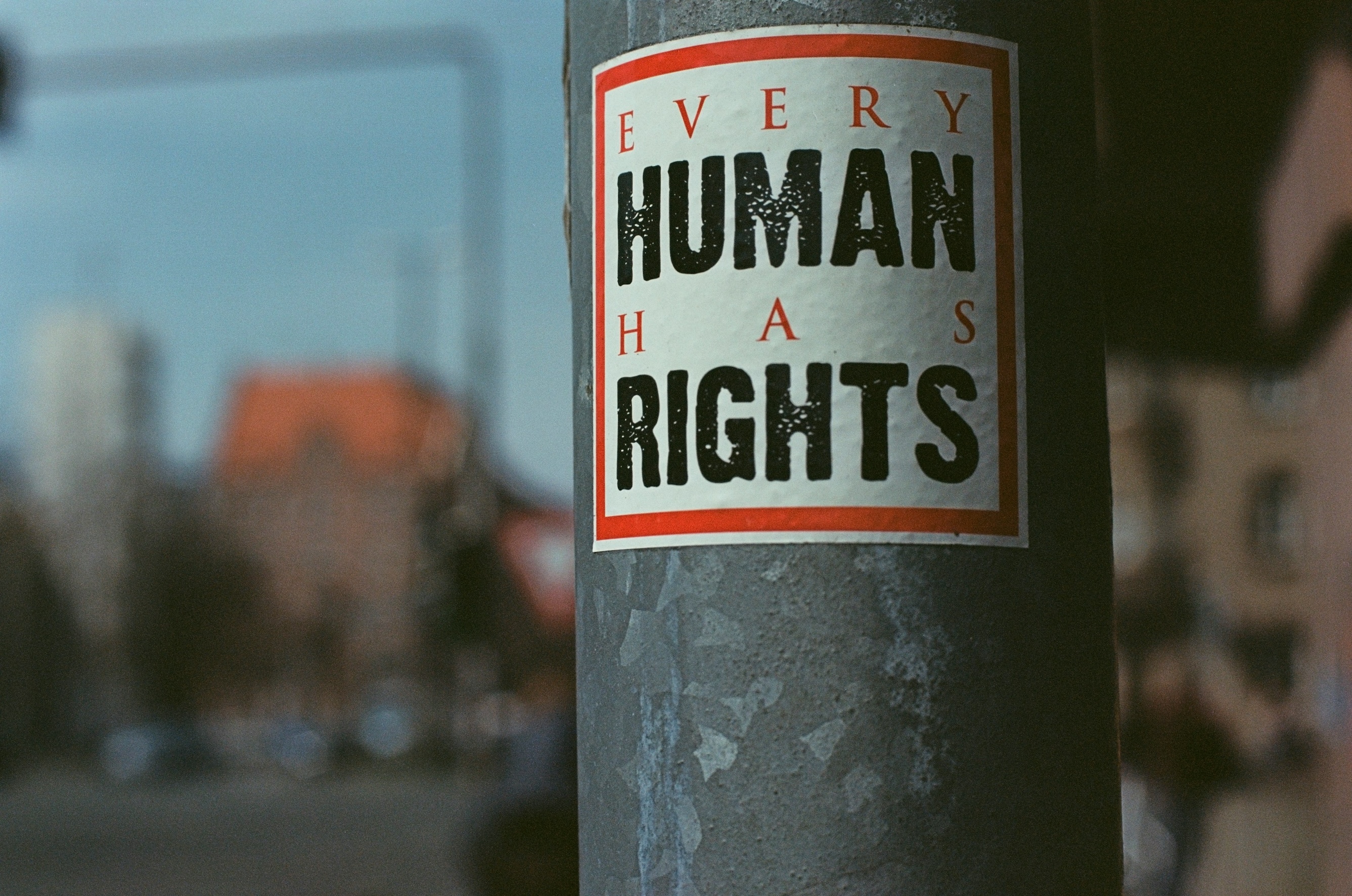Sticker on a light pole that reads "EVERY HUMAN HAS RIGHTS"