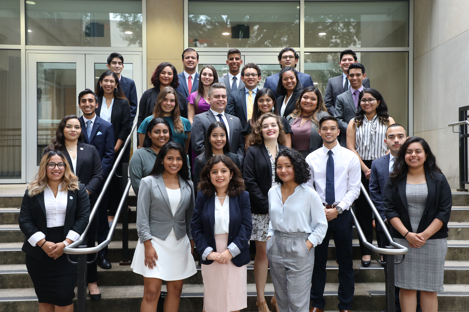 3 cohorts of Cisneros scholars stand together on steps outside the Hall of Government