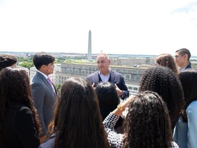Gilbert Cisneros, B.A. ’94, spoke with students from Caminos al Futuro on the terrace of the City View Room overlooking the Washington Monument. (Photos: Marcelo Gonzales)