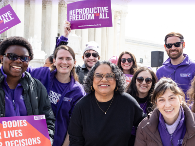 People standing in front of Supreme Court with sign that reads, "Reproductive Freedom for All"