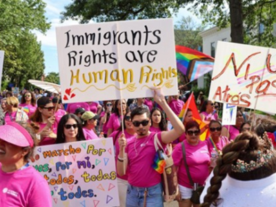 Multiple people at a protest holding up signs