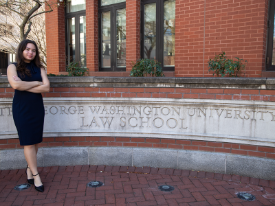 Student stands in front a law school building