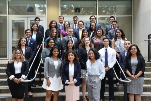 3 cohorts of Cisneros scholars stand together on steps outside the Hall of Government