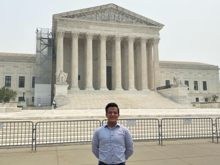 Student standing in front of the Supreme Court