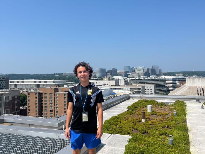 Student posing with the skyline behind them