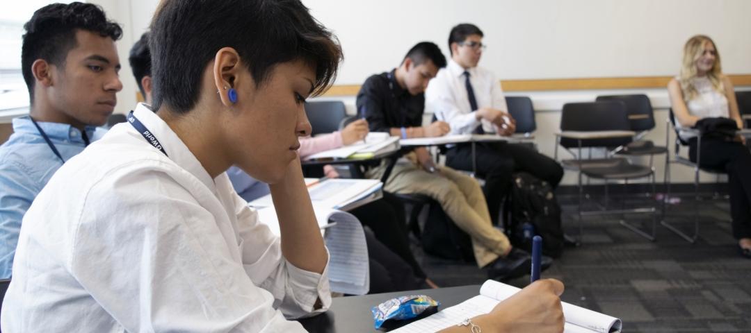 Caminos al Futuro Participant writes on notebook