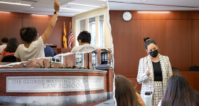 Three images of the GW Law School featuring professor speaking to students and a student raising their hand