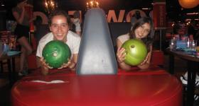 Two people holding bowling balls