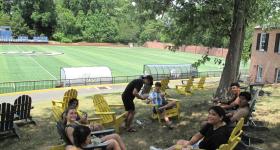 Students sitting in chairs in a field