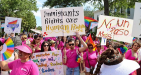 Multiple people at a protest holding up signs