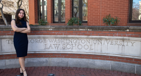 Student stands in front a law school building